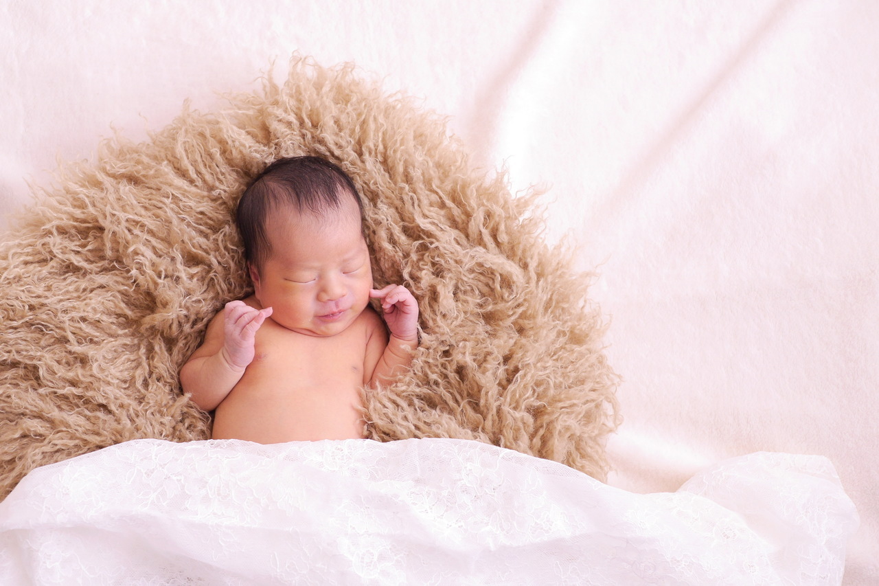 母が娘の出産祝いとして依頼したニューボーンフォト。赤ちゃんがふわふわのファーの上で安心して眠る姿を撮影。