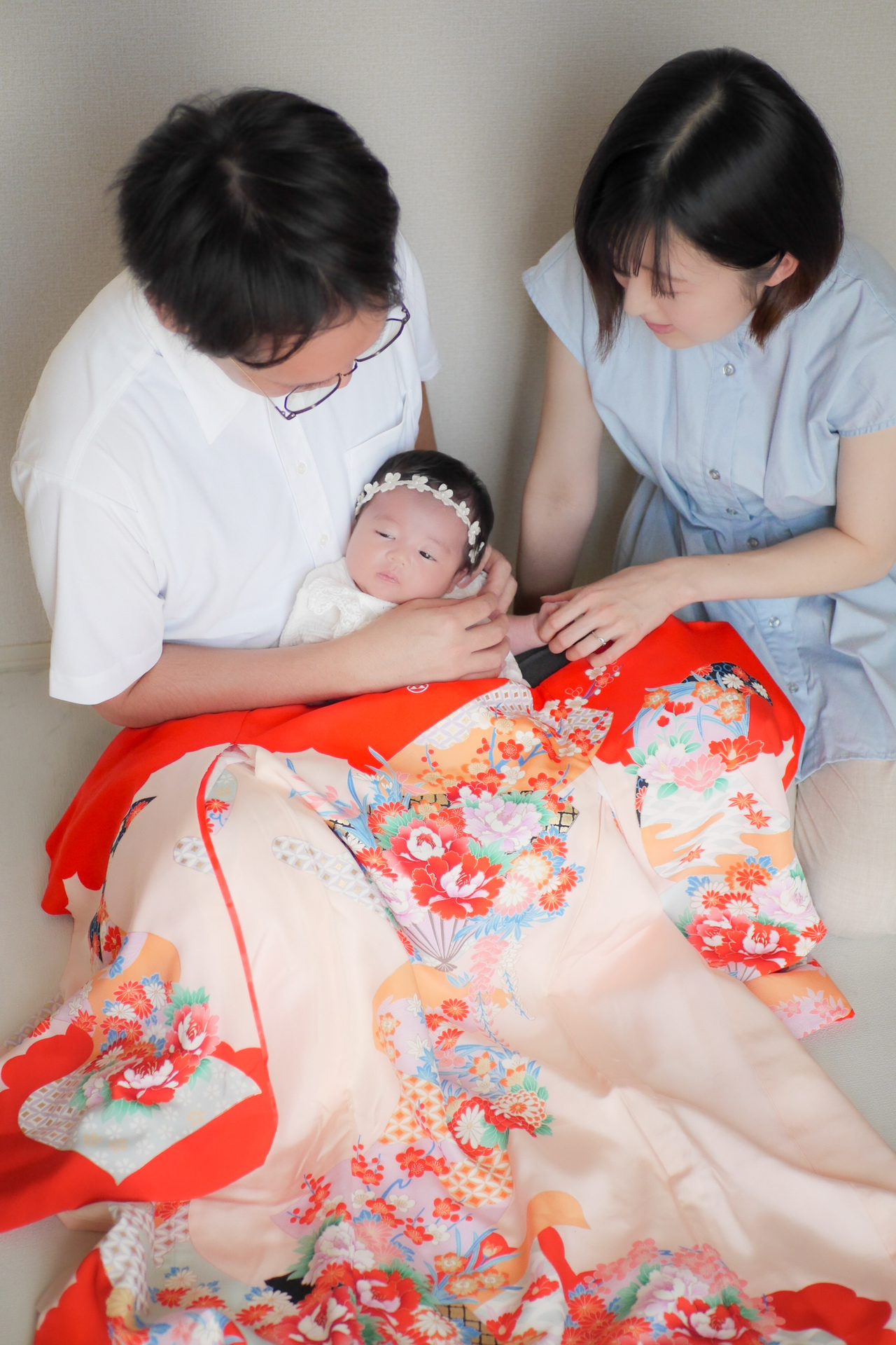 自宅出張お宮参り写真両親に抱っこされている産着姿の赤ちゃん