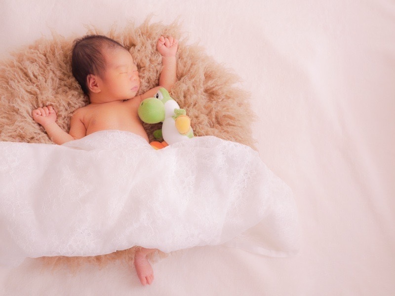 パパが選んだトイと並ぶニューボーンフォトの赤ちゃん。退院前に知っておきたいポイントを解説